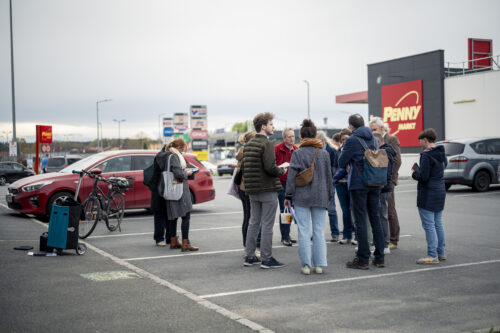 Menschengruppe auf einem Supermarkt-Parkplatz während eines Soil Walks